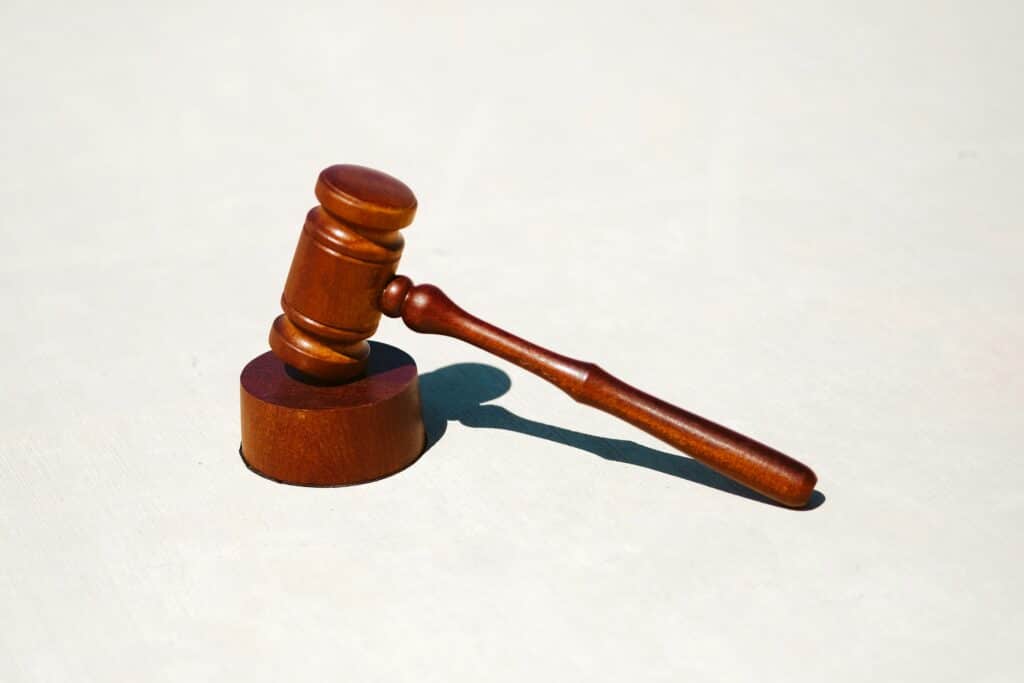 Isolated image of a wooden gavel on a light beige background.