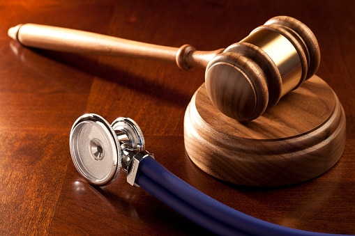 gavel and stethoscope on wood table
